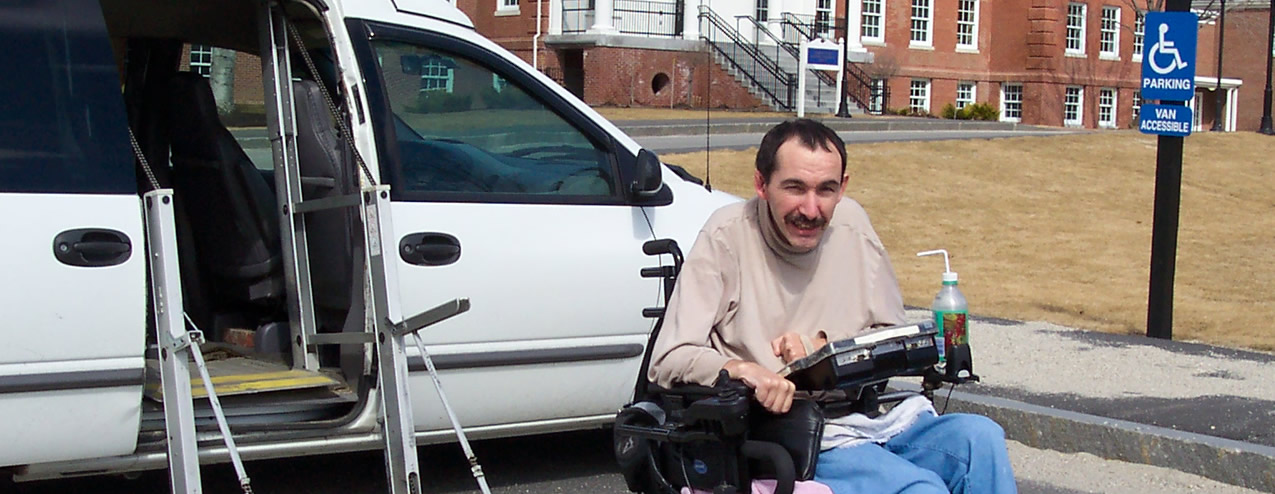 A man posing in a wheelchair in front of his van