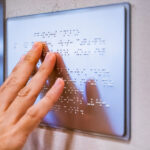Hand on Braille sign