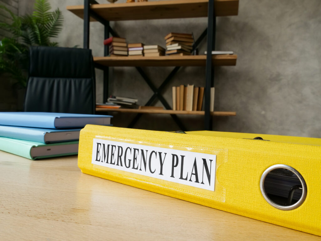 Yellow folder on desk that says Emergency Plan.
